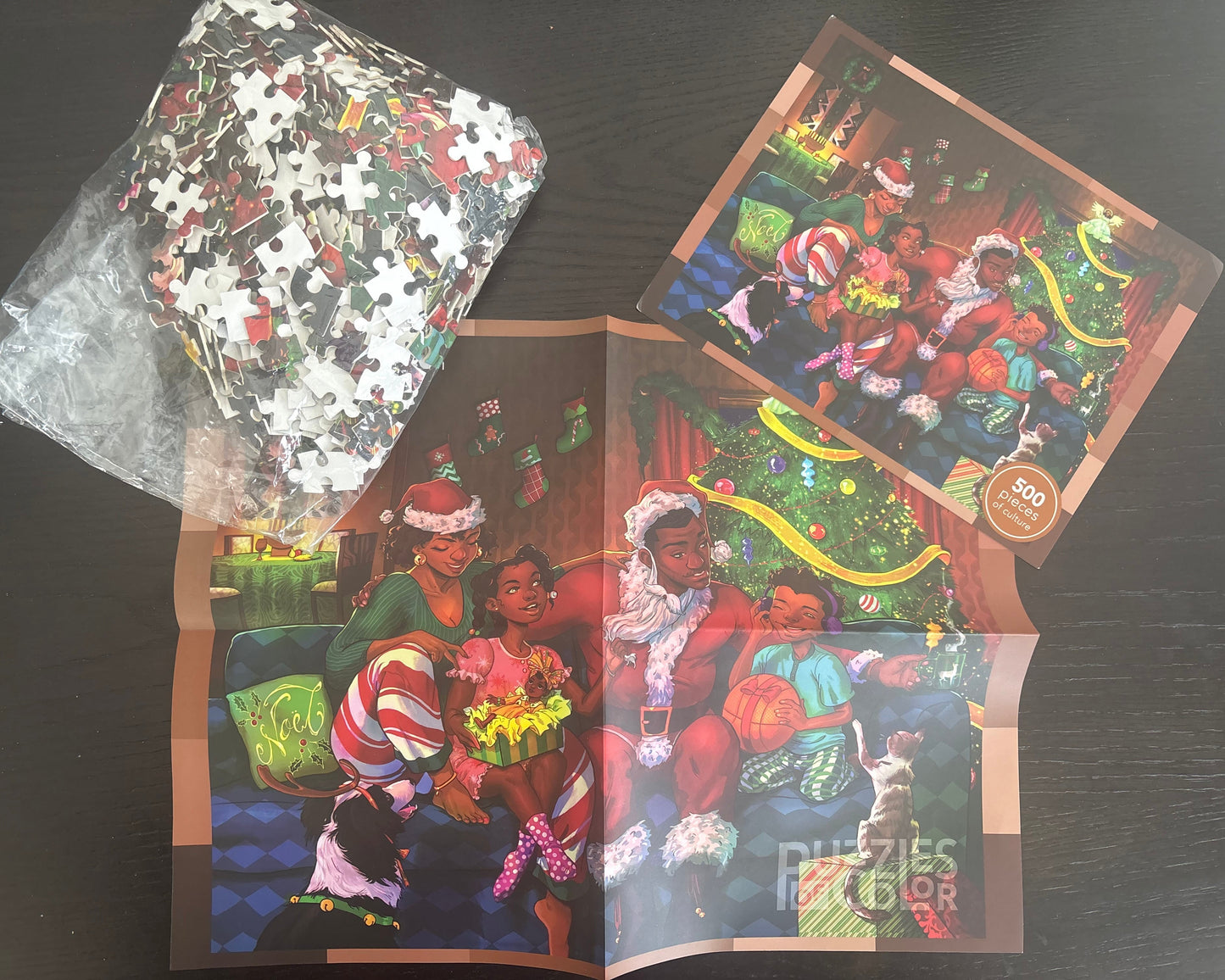 Jigsaw puzzle packaging with a festive scene of people around a Christmas tree.